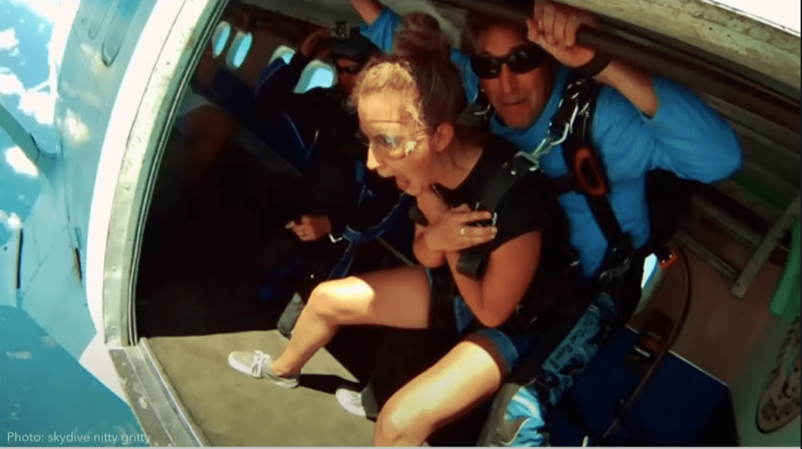 Woman screaming as she is about to jump out of a plane to skydive